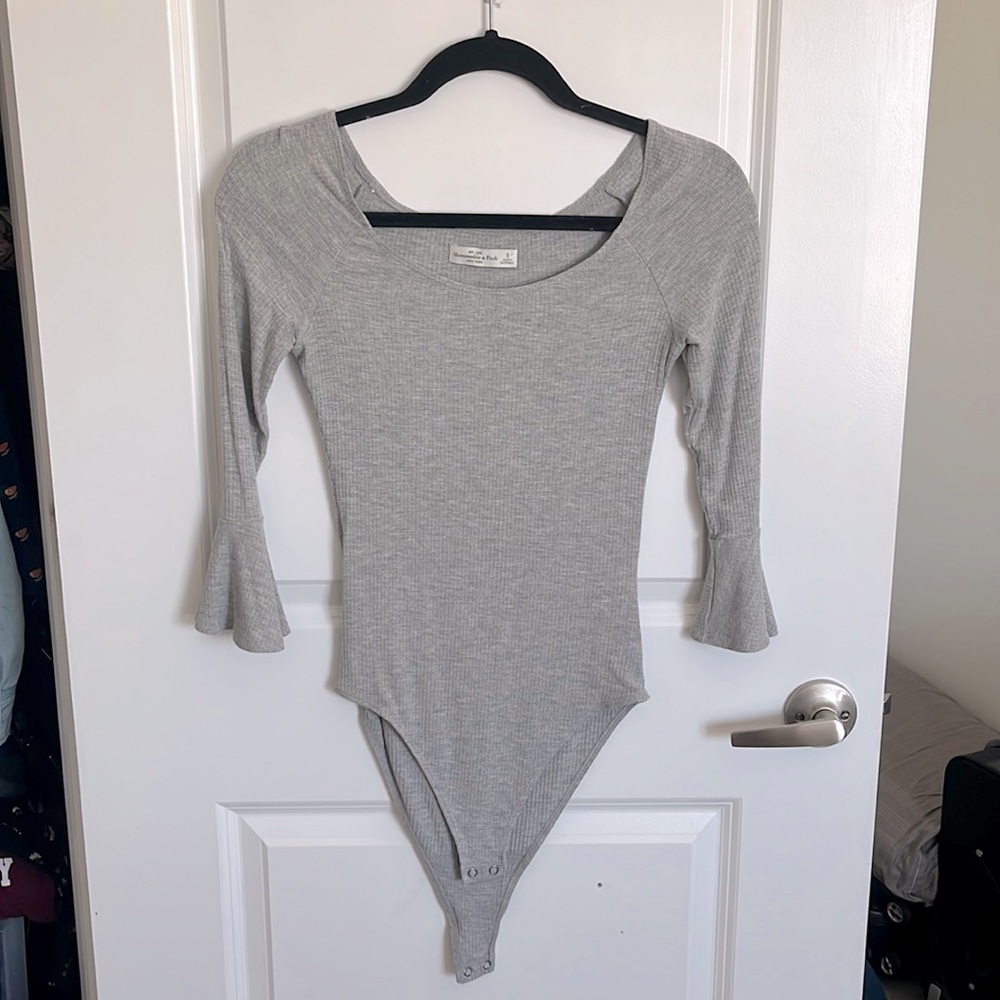 Bodysuit with snap enclosure and fluttery sleeves that end at the elbow